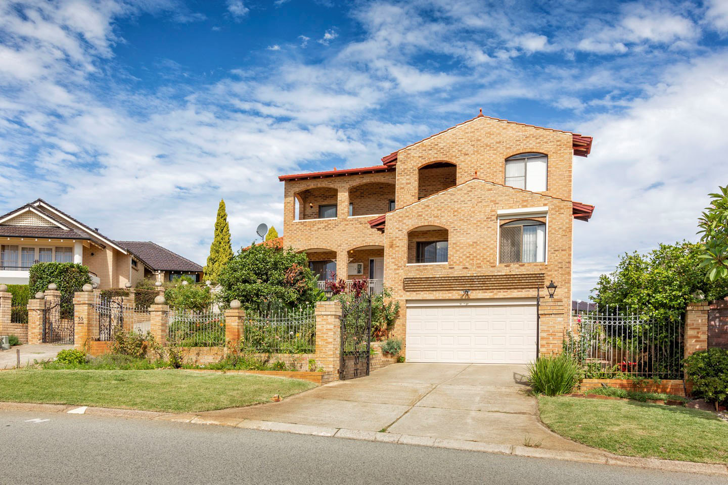 Two-story brick house with garage in suburban area.
